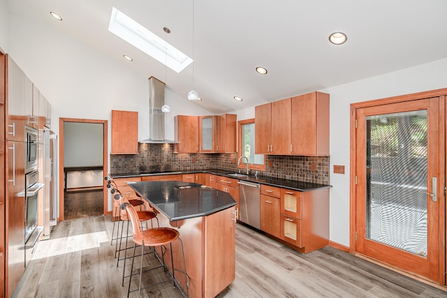 14 Old Bridge Rd W, New Fairfield, CT 06812 - kitchen featuring stainless steel appliances, wall chimney exhaust hood, a sink, a skylight, and light wood-style floors