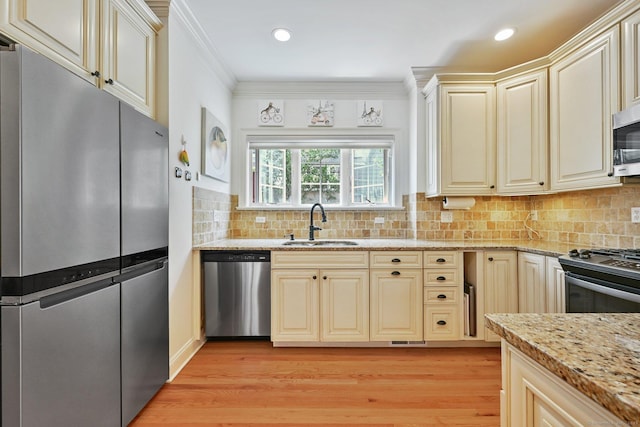 43 Harold St Unit B, Greenwich, CT 06807 - kitchen featuring stainless steel appliances, cream cabinets, a sink, light wood finished floors, and light stone counters