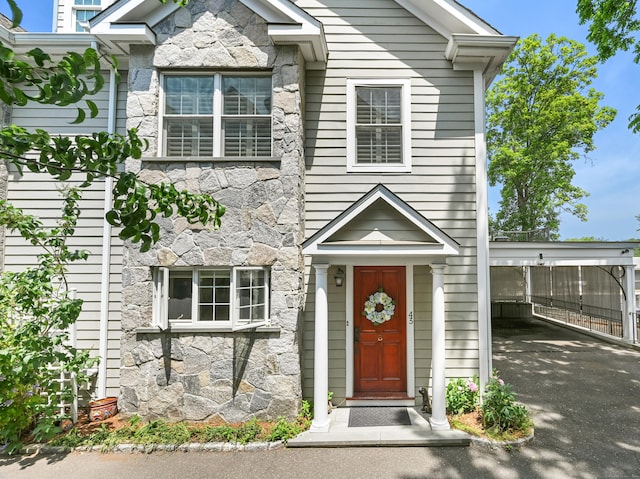 43 Harold St Unit B, Greenwich, CT 06807 - view of front of house with stone siding, driveway, and a carport