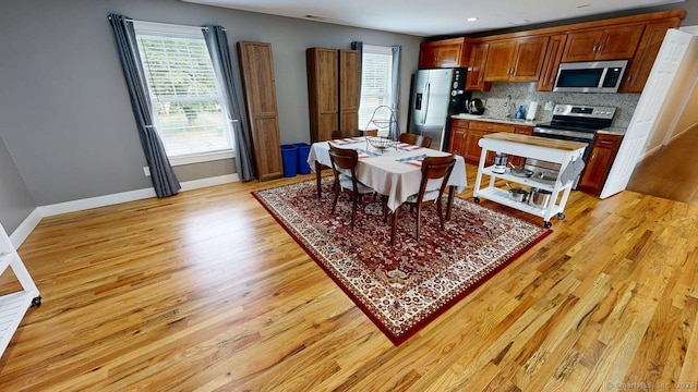 435 Maple Ave, Cheshire, CT 06410 - kitchen with stainless steel appliances, light wood-style floors, light countertops, tasteful backsplash, and brown cabinetry