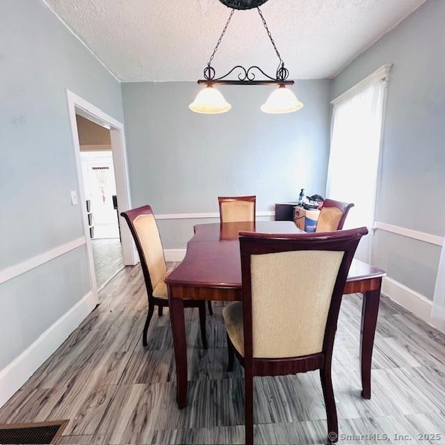22 Webb St, Hamden, CT 06517 - dining space with a textured ceiling, light wood-style floors, and baseboards