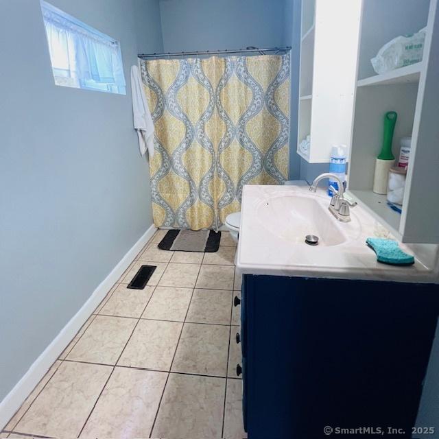 22 Webb St, Hamden, CT 06517 - full bath featuring vanity, tile patterned flooring, toilet, baseboards, and a shower with shower curtain