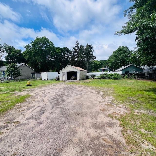 22 Webb St, Hamden, CT 06517 - view of front facade featuring dirt driveway, a garage, and an outdoor structure