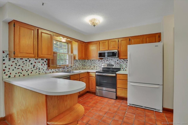 10 Crown Rdg Unit 10, Newington, CT 06111 - kitchen with appliances with stainless steel finishes, light countertops, a peninsula, tasteful backsplash, and a sink