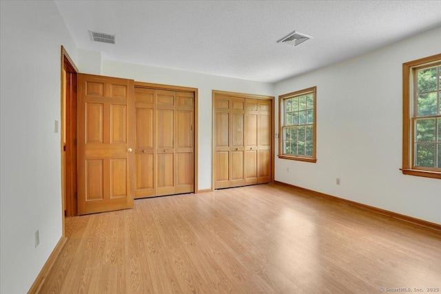 10 Crown Rdg Unit 10, Newington, CT 06111 - unfurnished bedroom featuring two closets, light wood finished floors, and baseboards