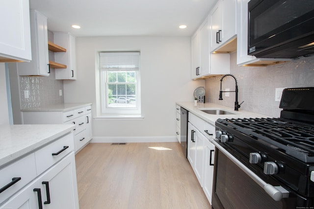 14 Hubbard Run Dr Unit 14, Glastonbury, CT 06033 - kitchen featuring gas stove, black microwave, a sink, baseboards, and light wood-style floors