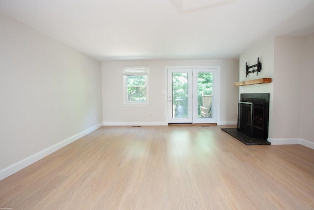 14 Hubbard Run Dr Unit 14, Glastonbury, CT 06033 - unfurnished living room featuring a fireplace with raised hearth, light wood-style flooring, and baseboards
