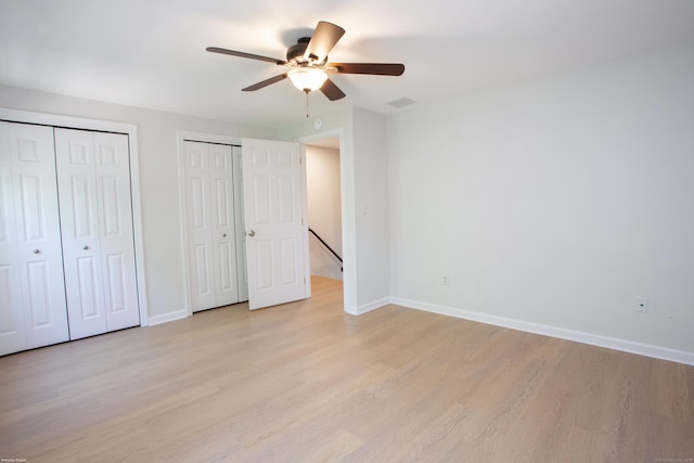 14 Hubbard Run Dr Unit 14, Glastonbury, CT 06033 - unfurnished bedroom featuring two closets, light wood finished floors, baseboards, and ceiling fan