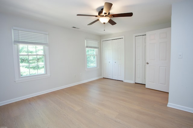 14 Hubbard Run Dr Unit 14, Glastonbury, CT 06033 - unfurnished bedroom featuring two closets, light wood-type flooring, baseboards, and a ceiling fan