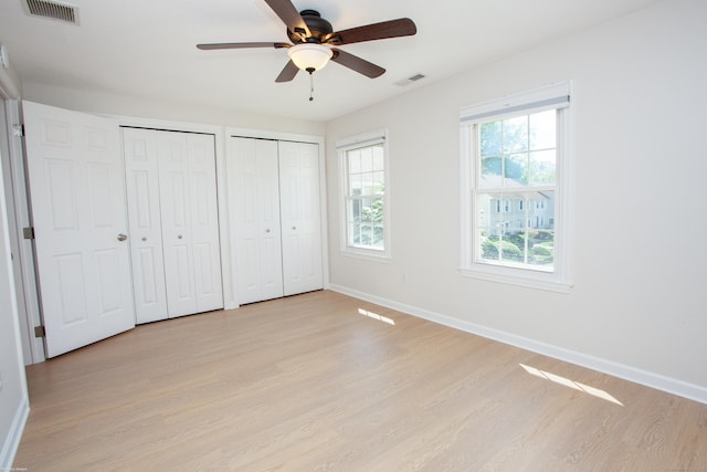 14 Hubbard Run Dr Unit 14, Glastonbury, CT 06033 - unfurnished bedroom with multiple closets, light wood-style flooring, baseboards, and ceiling fan