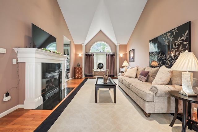 136 Thistle Pond Dr Unit 136, Bloomfield, CT 06002 - living room with wood finished floors, decorative columns, baseboards, a fireplace with flush hearth, and vaulted ceiling