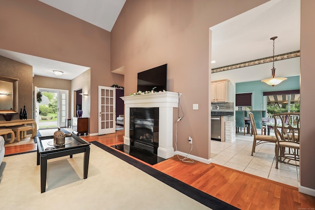 136 Thistle Pond Dr Unit 136, Bloomfield, CT 06002 - living room featuring light wood-style flooring, a fireplace with flush hearth, baseboards, and a high ceiling