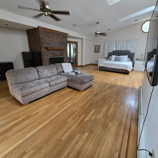 240 Mountain Spring Rd, Tolland, CT 06084 - living room featuring ceiling fan, light wood-style flooring, lofted ceiling, a fireplace, and a skylight
