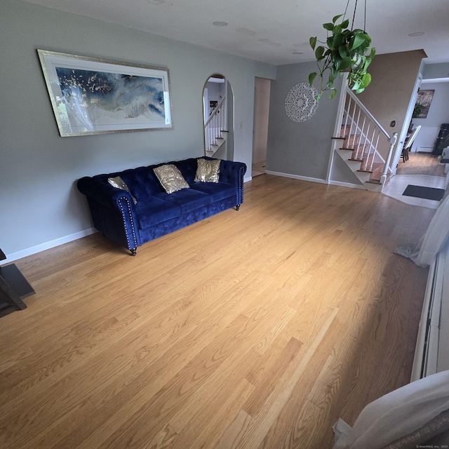 240 Mountain Spring Rd, Tolland, CT 06084 - living room featuring stairs, arched walkways, wood finished floors, and baseboards