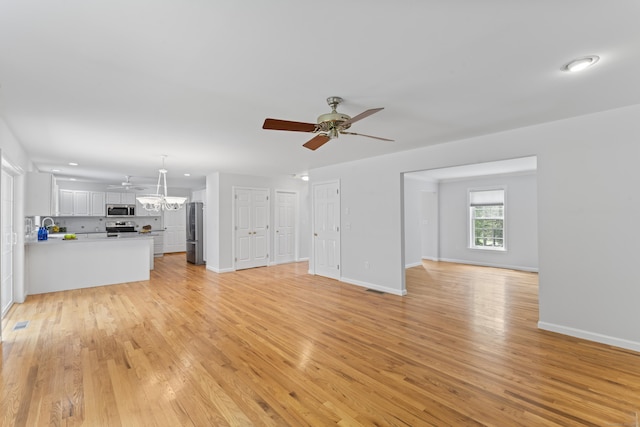8 Stone Gate Dr, Newtown, CT 06482 - unfurnished living room featuring ceiling fan, a chandelier, light wood-style flooring, and recessed lighting