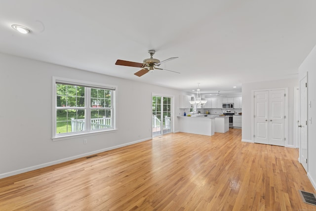 8 Stone Gate Dr, Newtown, CT 06482 - unfurnished living room with a chandelier, a ceiling fan, and light wood-type flooring