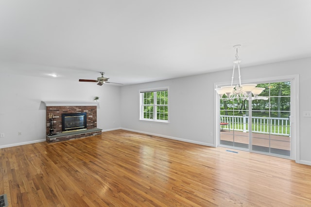 8 Stone Gate Dr, Newtown, CT 06482 - unfurnished living room with wood finished floors, a ceiling fan, a fireplace, and a chandelier