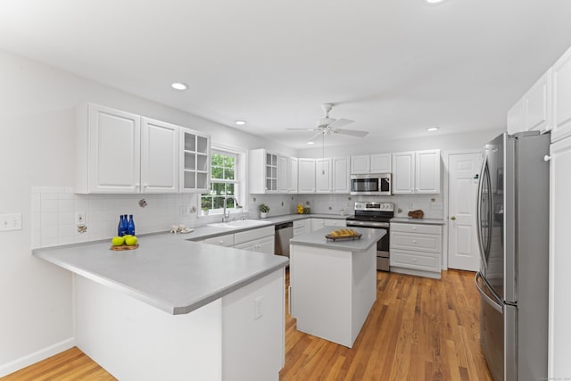 8 Stone Gate Dr, Newtown, CT 06482 - kitchen featuring stainless steel appliances, a peninsula, decorative backsplash, light wood finished floors, and recessed lighting