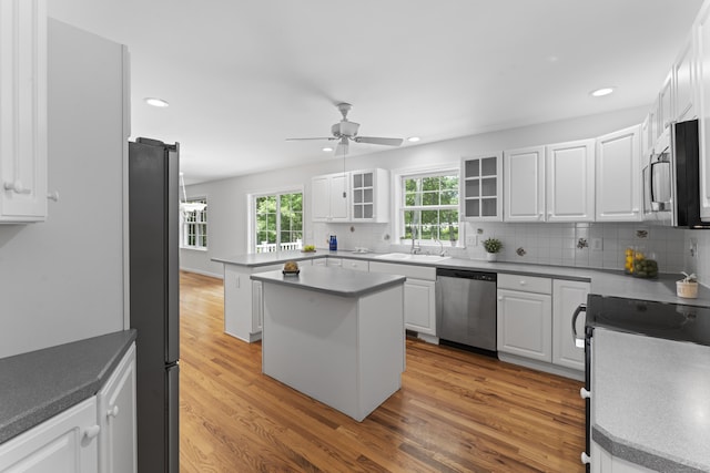 8 Stone Gate Dr, Newtown, CT 06482 - kitchen featuring stainless steel appliances, ceiling fan, light wood finished floors, decorative backsplash, and white cabinetry