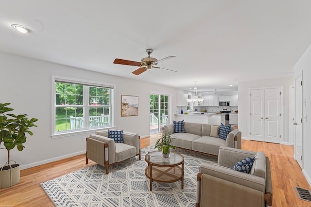 8 Stone Gate Dr, Newtown, CT 06482 - living area with a ceiling fan, light wood-style flooring, and a chandelier