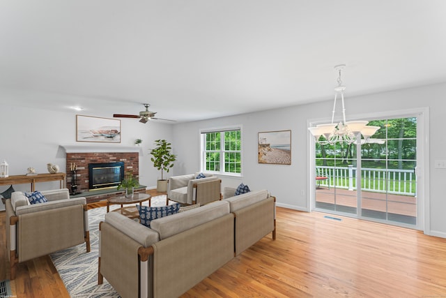 8 Stone Gate Dr, Newtown, CT 06482 - living area with a brick fireplace, light wood-type flooring, ceiling fan, and a chandelier