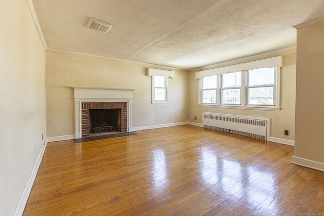 47 Yale St, Hartford, CT 06114 - unfurnished living room featuring radiator heating unit, crown molding, a textured ceiling, wood finished floors, and a fireplace