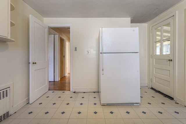 47 Yale St, Hartford, CT 06114 - kitchen with freestanding refrigerator, radiator, and light tile patterned floors