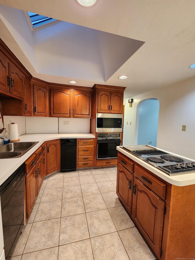 12 Hart Pl, Plainville, CT 06062 - kitchen with black appliances, arched walkways, light countertops, brown cabinetry, and light tile patterned floors
