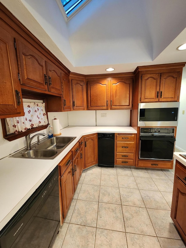 12 Hart Pl, Plainville, CT 06062 - kitchen with black appliances, light countertops, a skylight, light tile patterned floors, and brown cabinets
