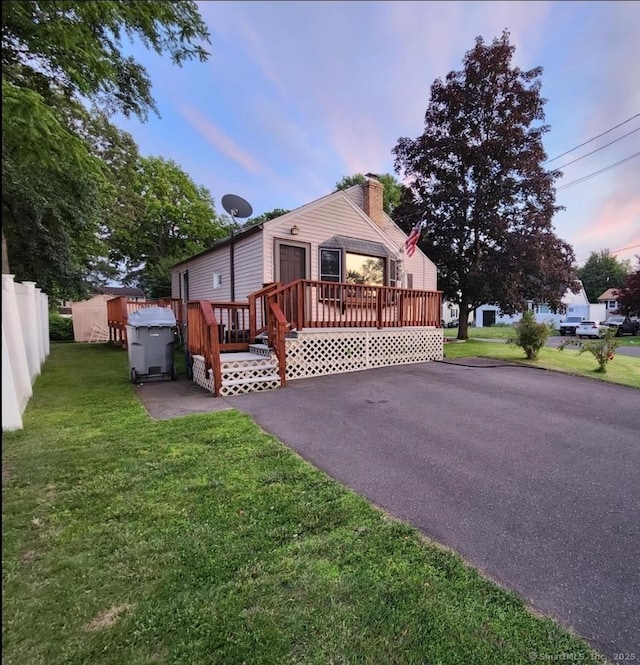 12 Hart Pl, Plainville, CT 06062 - view of front facade featuring a wooden deck, a chimney, and a front lawn