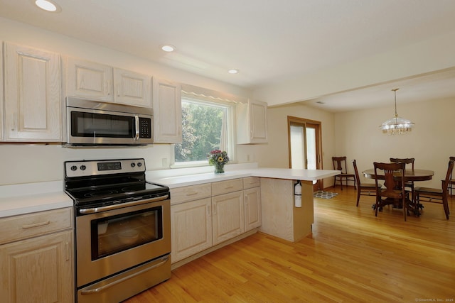 108 Northwood Dr, Easton, CT 06612 - kitchen with appliances with stainless steel finishes, a peninsula, light countertops, light wood finished floors, and recessed lighting
