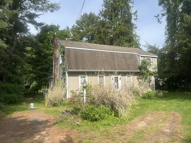 53 Falls Bashan Rd, East Haddam, CT 06469 - view of home's exterior featuring a gambrel roof, roof with shingles, and a chimney