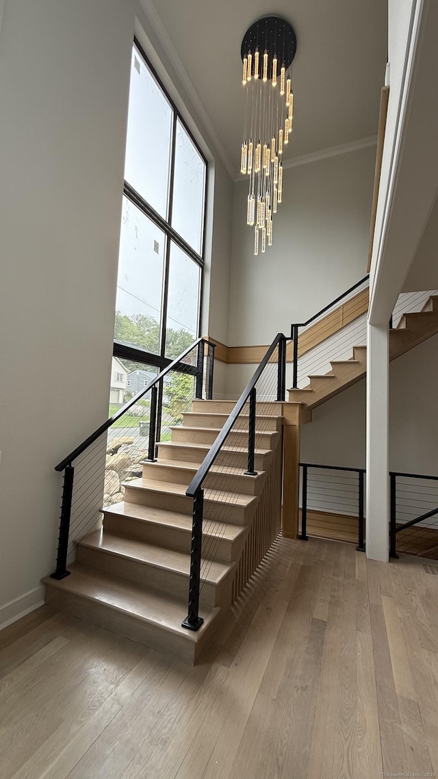 20 N Lake Shore Dr, Brookfield, CT 06804 - staircase featuring wood-type flooring, a chandelier, ornamental molding, and baseboards
