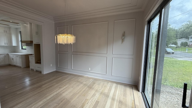 20 N Lake Shore Dr, Brookfield, CT 06804 - unfurnished dining area featuring light wood-type flooring, crown molding, a decorative wall, and a chandelier