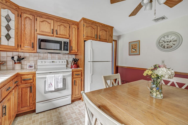 131 Ridgeview Ave, Trumbull, CT 06611 - kitchen with white appliances, tile counters, ceiling fan, backsplash, and brown cabinets