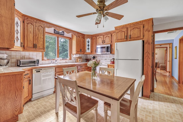 131 Ridgeview Ave, Trumbull, CT 06611 - kitchen featuring white appliances, a sink, tile countertops, tasteful backsplash, and brown cabinets