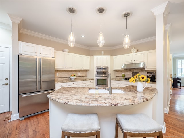 10 Wilton Hls Unit 10, Wilton, CT 06897 - kitchen featuring stainless steel appliances, ornamental molding, a sink, under cabinet range hood, and white cabinets