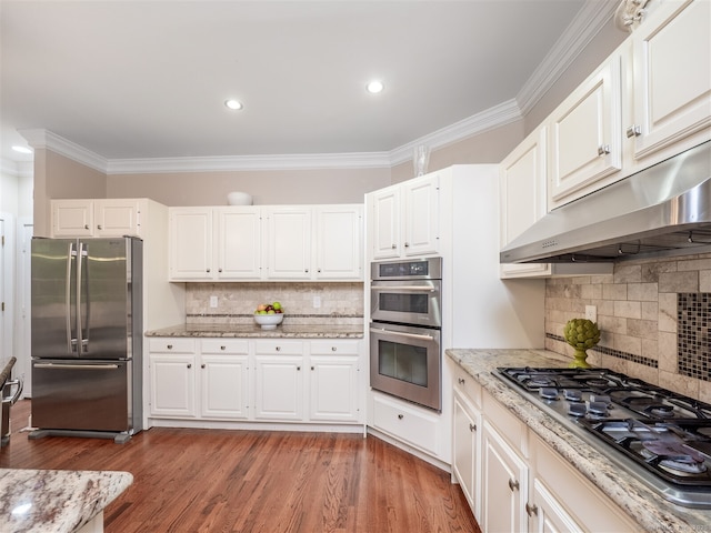 10 Wilton Hls Unit 10, Wilton, CT 06897 - kitchen featuring appliances with stainless steel finishes, under cabinet range hood, crown molding, backsplash, and light stone counters