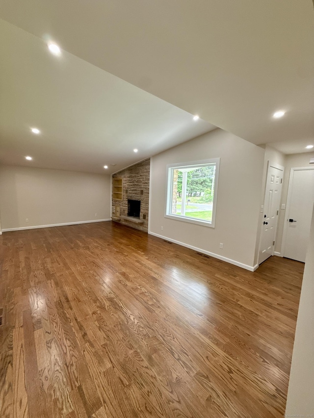 9 Grieb Rd, Wallingford, CT 06492 - unfurnished living room with wood finished floors, baseboards, a large fireplace, lofted ceiling, and recessed lighting