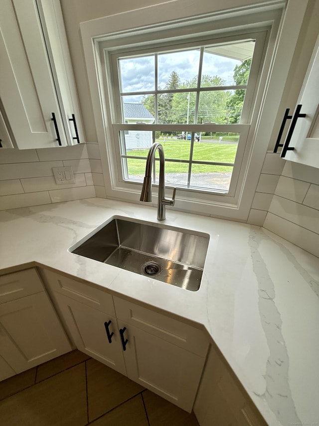 9 Grieb Rd, Wallingford, CT 06492 - kitchen featuring a sink, white cabinets, decorative backsplash, and light stone counters