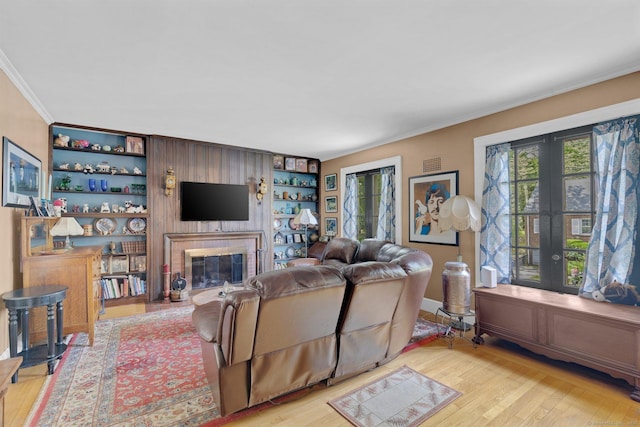 73 Hemlock Rd, New Haven, CT 06515 - living room with wood finished floors, ornamental molding, built in shelves, french doors, and a glass covered fireplace