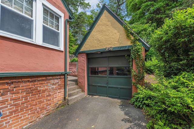 73 Hemlock Rd, New Haven, CT 06515 - view of side of property with an outbuilding, driveway, a garage, and stucco siding