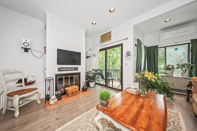 26 Evergreen Rd Unit 26, Torrington, CT 06790 - living area featuring wood finished floors, a wall unit AC, a fireplace with flush hearth, and recessed lighting