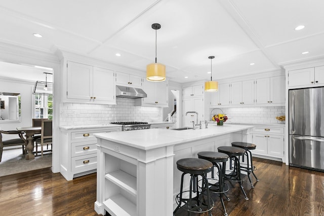 7 Over Rock Ln, Westport, CT 06880 - kitchen with freestanding refrigerator, under cabinet range hood, white cabinetry, an island with sink, and recessed lighting