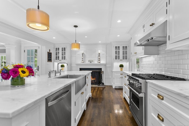 7 Over Rock Ln, Westport, CT 06880 - kitchen featuring stainless steel appliances, under cabinet range hood, white cabinets, decorative backsplash, and ornamental molding