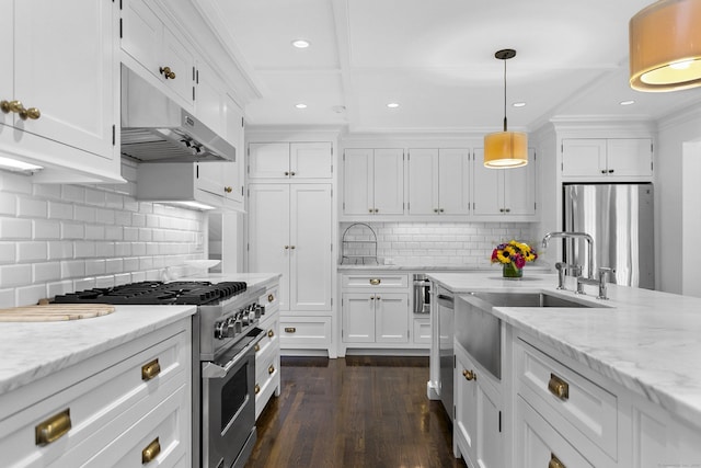 7 Over Rock Ln, Westport, CT 06880 - kitchen with appliances with stainless steel finishes, under cabinet range hood, white cabinetry, recessed lighting, and tasteful backsplash
