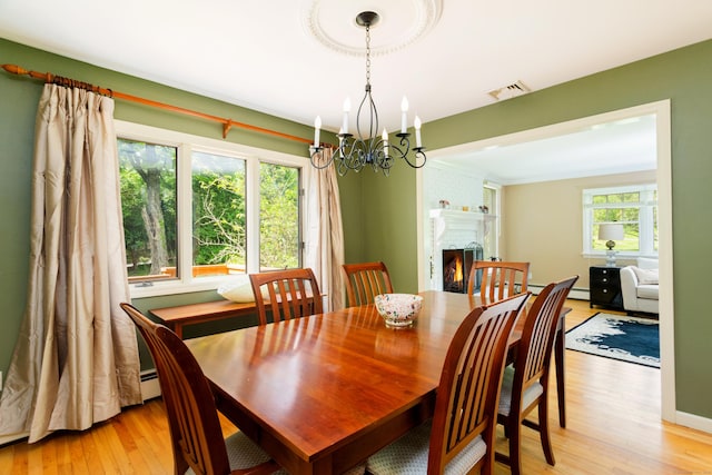 21 Forest Rd, Weston, CT 06883 - dining room with light wood-style floors, a chandelier, and a fireplace