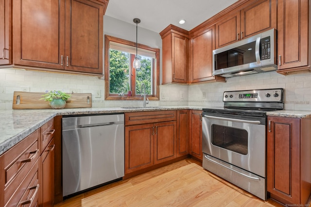 31 S Meadow Ln, Enfield, CT 06082 - kitchen featuring appliances with stainless steel finishes, a sink, brown cabinets, light stone counters, and recessed lighting