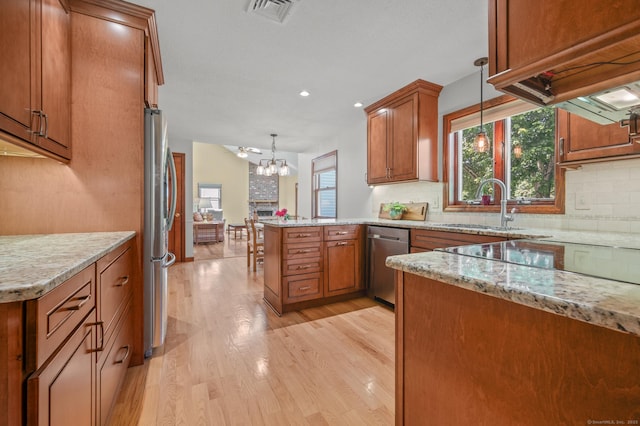 31 S Meadow Ln, Enfield, CT 06082 - kitchen with appliances with stainless steel finishes, brown cabinets, a peninsula, backsplash, and recessed lighting
