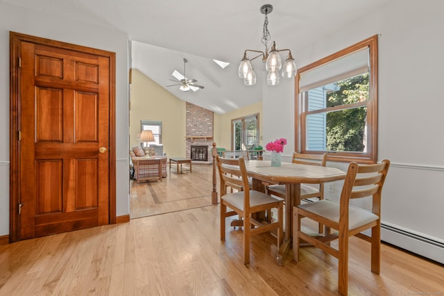 31 S Meadow Ln, Enfield, CT 06082 - dining space featuring a brick fireplace, a ceiling fan, light wood-style flooring, a skylight, and vaulted ceiling